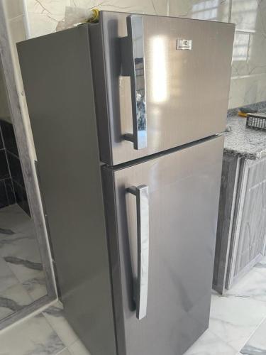 a stainless steel refrigerator is being constructed in a kitchen at Poolside Perfection - Private Pool & BBQ in Irbid