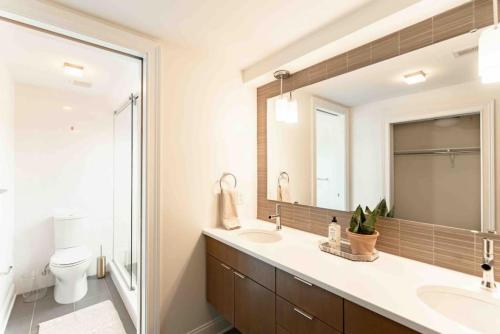 ein Badezimmer mit zwei Waschbecken und einem großen Spiegel in der Unterkunft Lux Washington Park w Rooftop Patio in Cincinnati