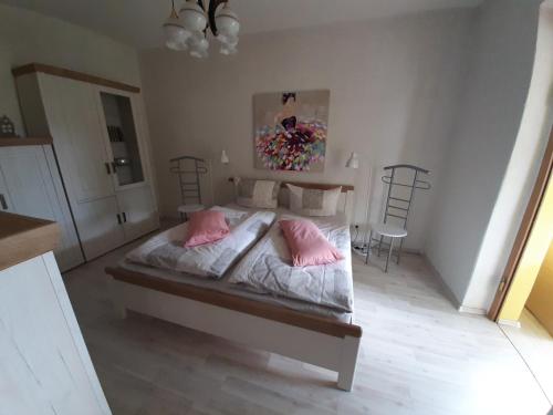 a bedroom with a bed with two pink pillows at Ferienhaus Hüthchen in Eichhorst
