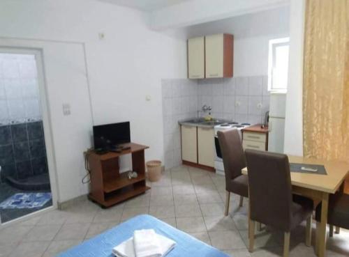 a kitchen with a table and chairs and a dining room at Apartmani Filipović in Bar