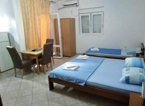 1 dormitorio con cama, escritorio y mesa con sillas en Apartmani Filipović en Bar