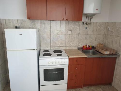 a kitchen with a white stove and a white refrigerator at Apartmani Filipović in Bar
