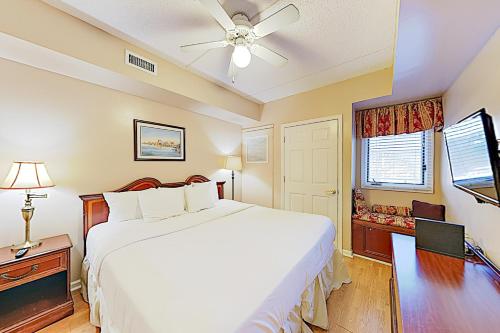 Schlafzimmer mit einem weißen Bett und einem Deckenventilator in der Unterkunft River View Suites 203 & 204 in Wilmington