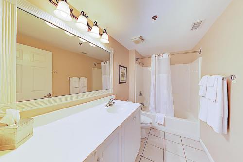 ein Badezimmer mit einem Waschbecken, einem WC und einem Spiegel in der Unterkunft River View Suites 203 & 204 in Wilmington