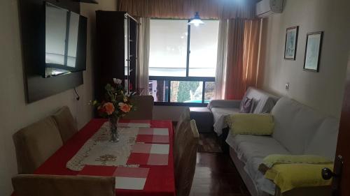una sala de estar con un sofá y una mesa en Apartamento Lindo e Aconchegante "com ou sem ar condicionado", en Porto Alegre