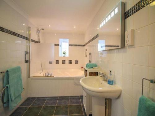 a bathroom with a tub and a sink and a bath tub at Charismatic Cottage near St Ives (Atlantic) in Saint Erth