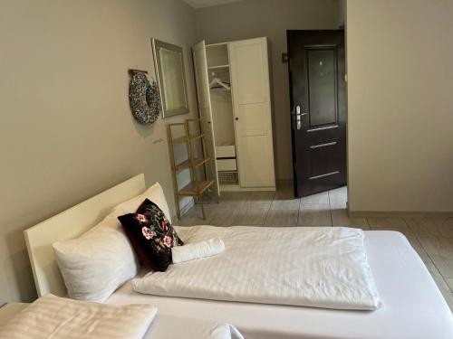 1 dormitorio con 1 cama blanca y 2 almohadas en Apartament Stara Piekarnia, en Tychy