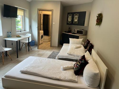 2 camas en una habitación con cocina y mesa en Apartament Stara Piekarnia, en Tychy