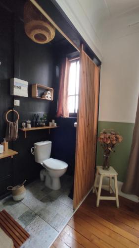 uma casa de banho com um WC e uma janela em Pavillon C.R em Isles-sur-Suippe