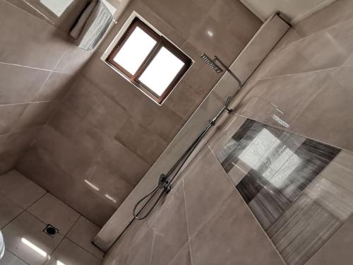 a bathroom with a shower with a window at Studio de luxe chez FOUR IN ONE Résidence in Limbe