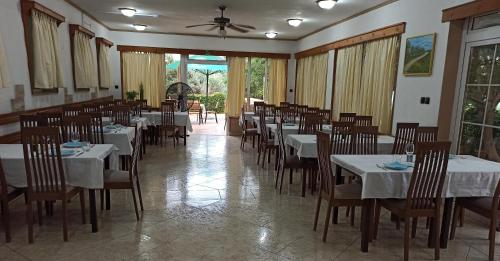 uma sala de jantar com mesas e cadeiras com toalhas de mesa brancas em Pansion TONY PAG em Pag