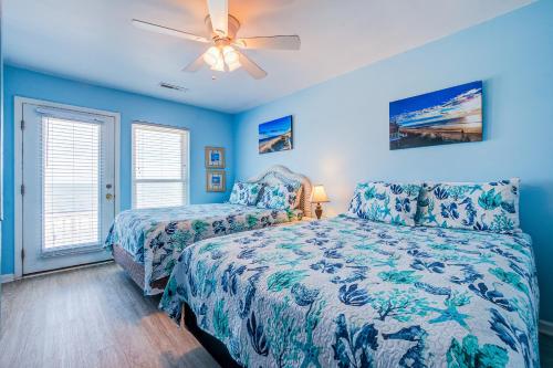 um quarto com 2 camas e uma ventoinha de tecto em KC's Seaside Sanctuary em Edisto Island