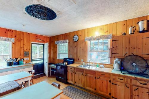 a kitchen with wooden cabinets and a sink and a stove at Garden Island's Maple in Charlotte