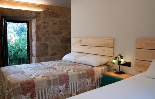 a bedroom with a bed and a window at Casa D'Mina in Redondela