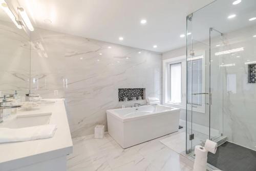 a white bathroom with a tub and a shower at Poolside Perfection, Culinary Delight in Mississauga