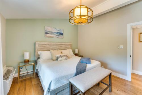 a bedroom with a large bed and a chandelier at Elegant 4-Season Lake Geneva Condo with Fireplace! in Lake Geneva