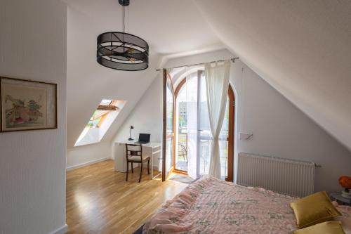 a bedroom with a bed and a desk and a window at Zakątek Apartments in Kraków