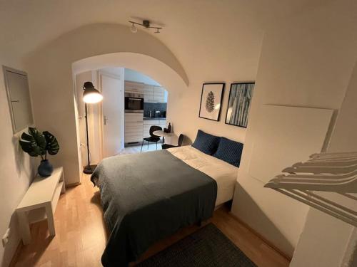 a bedroom with a bed and a room with a kitchen at Franziskaner Suites #6 in Graz