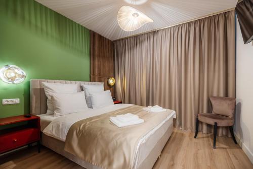 1 dormitorio con 1 cama grande y 1 silla en Studio 7 The Lake Home en Sibiu