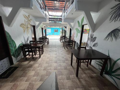 a hallway with tables and chairs in a restaurant at Toca do Pato Hospedagem in Trindade