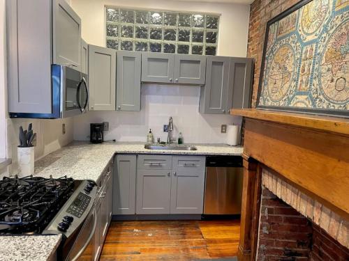 a kitchen with white cabinets and a stove top oven at Loft in the heart of Over-The-Rhine in Cincinnati