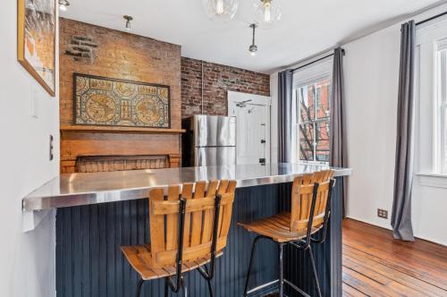 a kitchen with a bar with chairs and a refrigerator at Loft in the heart of Over-The-Rhine in Cincinnati