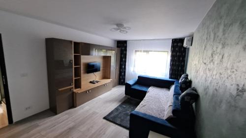 a living room with a blue couch and a television at Apartament lângă Port Turistic Mangalia 2 camere decomandate, renovat 2023 in Mangalia