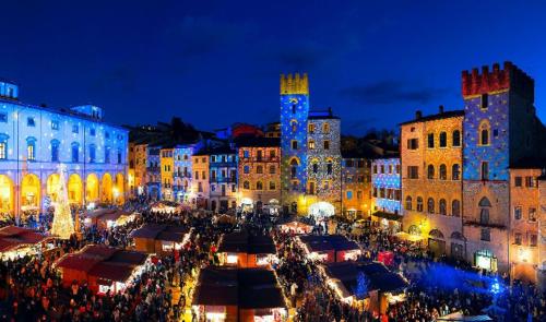 a crowd of people standing around a market at night at Casa Buonconte in Arezzo