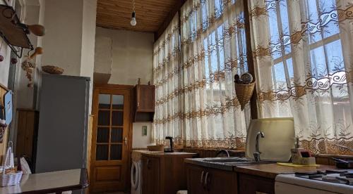 cocina con fregadero y algunas ventanas en Beautiful 2-room apartment hosted by a Georgian Artist, en Tiflis
