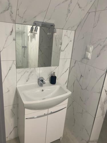 a white bathroom with a sink and a mirror at Mega widok 2 in Szklarska Poręba