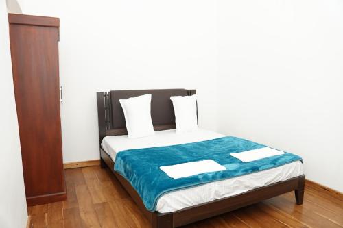 バッティカロアにあるNilo's Guest Houseの青い毛布が掛けられたベッドのある寝室