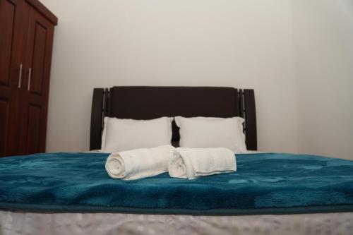 two towels sitting on top of a bed at Nilo's Guest House in Batticaloa