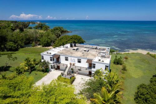 an aerial view of a white house with the ocean at Ivy's Cove Beach Side Condo - Luxury Villa in Whitehouse