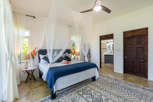 a bedroom with a bed with a blue comforter at Ivy's Cove Beach Side Condo - Luxury Villa in Whitehouse