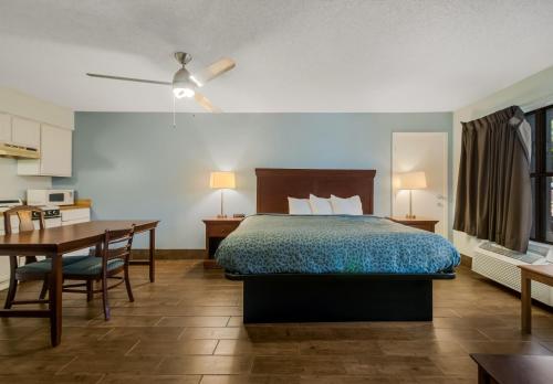 a hotel room with a bed and a desk and a table at Econo Lodge Inn & Suites Fulton - Rockport in Rockport