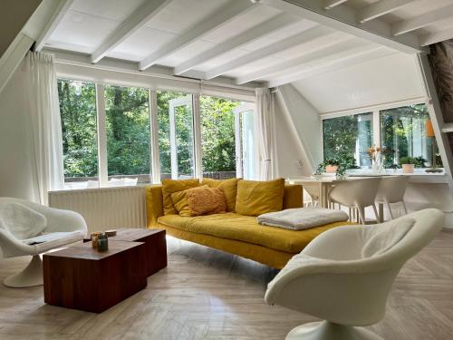 a living room with a yellow couch and a table at Vakantiewoning Sunclass Durbuy Ardennen huisnummer 68 in Durbuy