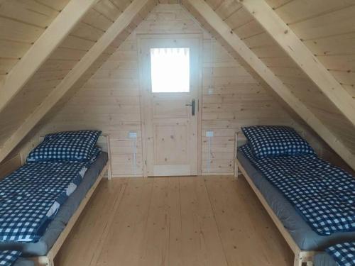 2 Betten in einem Dachzimmer mit Fenster in der Unterkunft "Chatki Nad Zalewem" Kluczbork in Ligota Zamecka