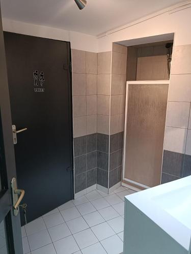 La salle de bains est pourvue d'une porte noire et d'une douche. dans l'établissement Chez Catherine & Ludovic, à Friville-Escarbotin