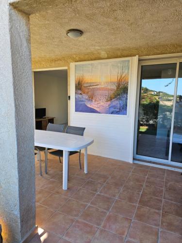 ein Esszimmer mit einem Tisch und einem Fenster in der Unterkunft Appartement 2 chambres in Cavalaire-sur-Mer