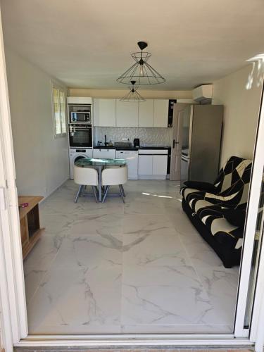 un salon avec une table et une cuisine dans l'établissement Appartement 2 chambres, à Cavalaire-sur-Mer