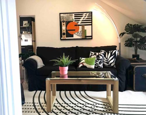 a living room with a black couch and a coffee table at THE MORNINGSIDE APARTMENT Charming stylish apartment in the centre of Innerleithen in Innerleithen