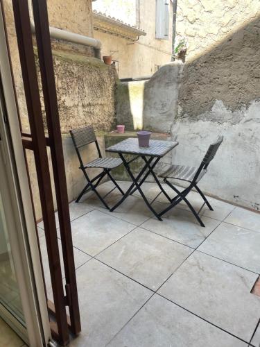 a table and two chairs on a patio at Appartement cœur de ville aux portes du Luberon in Cavaillon