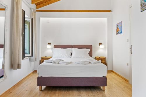 ein Schlafzimmer mit einem großen Bett mit weißer Bettwäsche in der Unterkunft Myrtillo II Sea View Villa in Spanokhórion