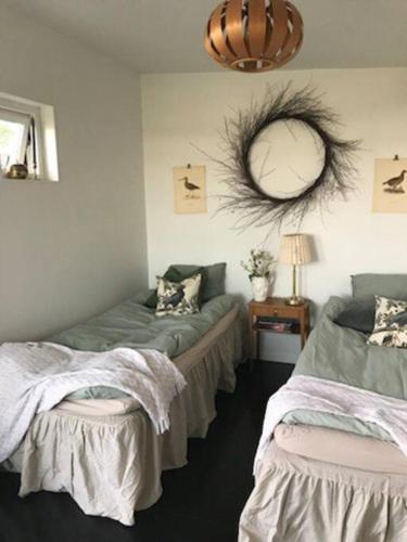 1 Schlafzimmer mit 2 Betten und einem Wandspiegel in der Unterkunft Boende nära havet in Varberg