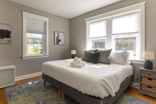 Un dormitorio con una cama grande con dos ventanas. en Hyde Park Comfort Near Rookwood, en Cincinnati