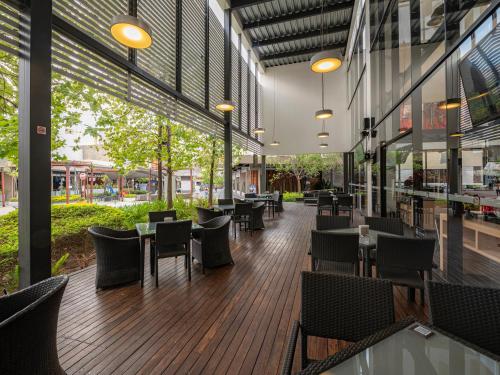 a restaurant with tables and chairs in a building at Ramada Encore by Wyndham Guadalajara Sur in Guadalajara