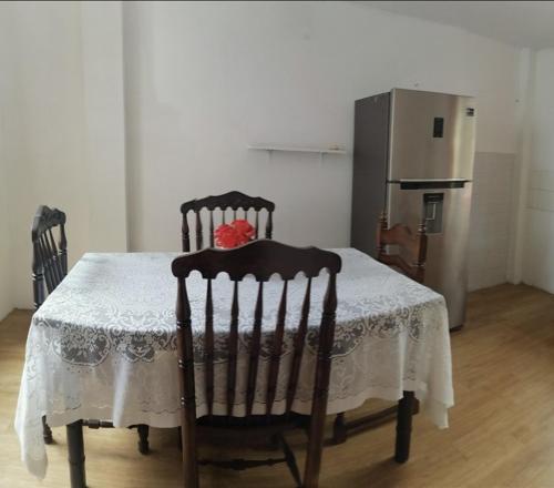 a kitchen with a table with two chairs and a refrigerator at SAN PAOLY. in Trujillo