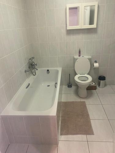 a bathroom with a bath tub and a toilet at Riekert's Self-Catering Apartment @Silver Sands in Swakopmund