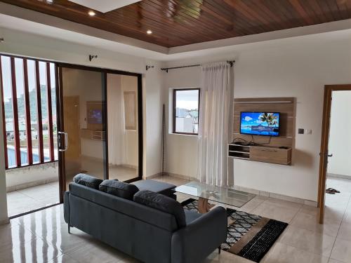 un soggiorno con divano e TV di FOUR IN ONE RESIDENTIAL HOMES a Limbe