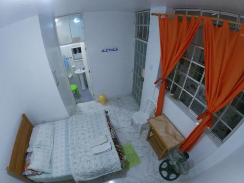 an overhead view of a bedroom with an orange curtain at Nanasqa Hostel en Nasca / Nazca in Nazca
